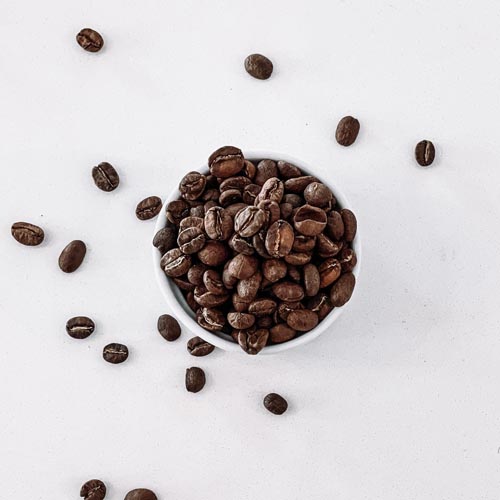 Whole coffee beans in a small bowl