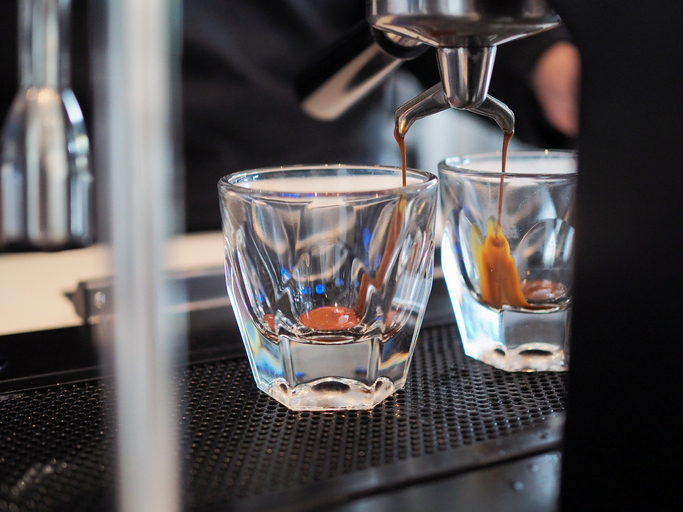 Barista pull down coffee maker machine filling espresso in shot, selective focus.